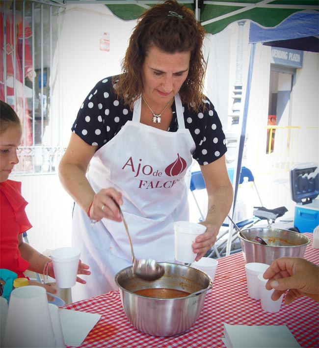 Una mujer sirve sopa de ajo