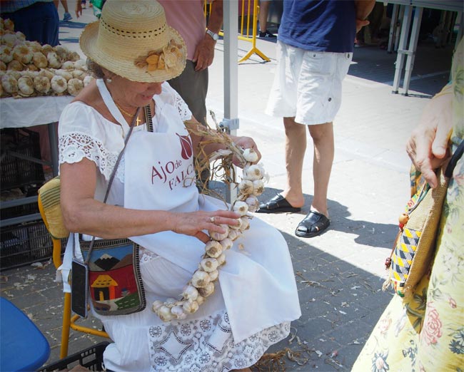 A woman prepares a pitchfork of garlic